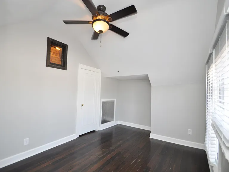 Large bedroom with vaulted ceiling, walk-in closet with chic barn door closure, Ceiling fan, and real Douglas fir hardwood floors. Picture window (left) lets sunlight into the hallway while maintaining privacy.