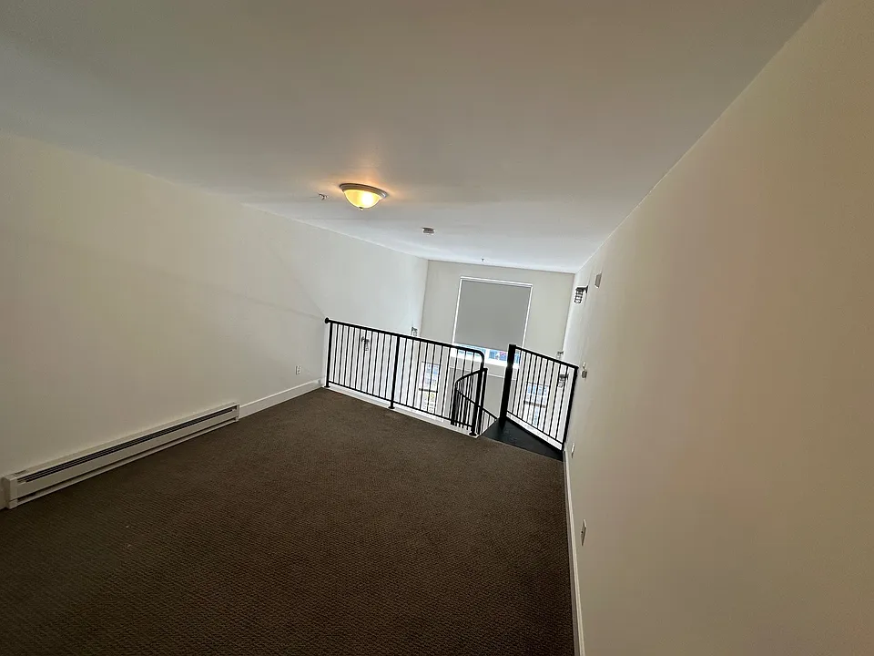 Lofted bedroom area looking toward staircase