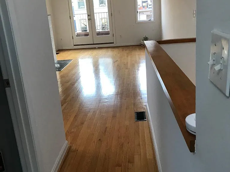 Long, beautiful living room showing steps to lower bedroom level. Access to utility closet with washer and dryer on left.