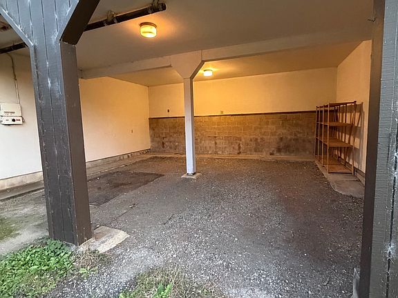 2 car garage, no doors, gravel floor room for storage.