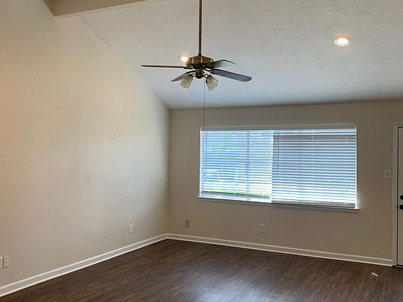 Living room with recessed lights and ceiling fan.