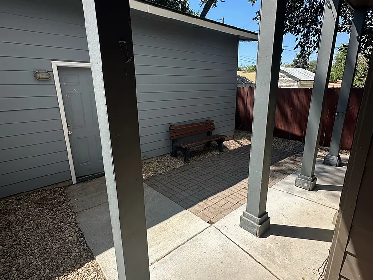 Back of the house going to the Garage, small patio area with table and chairs