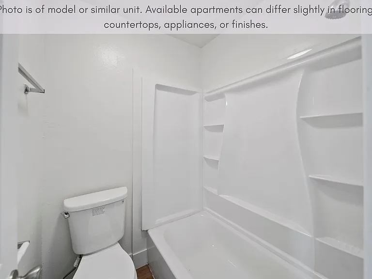 Clean tub and shower combination with built-in shelving for added convenience.