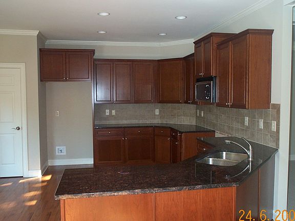 Kitchen with tile backsplash, grantie counter tops, and stained cabinets