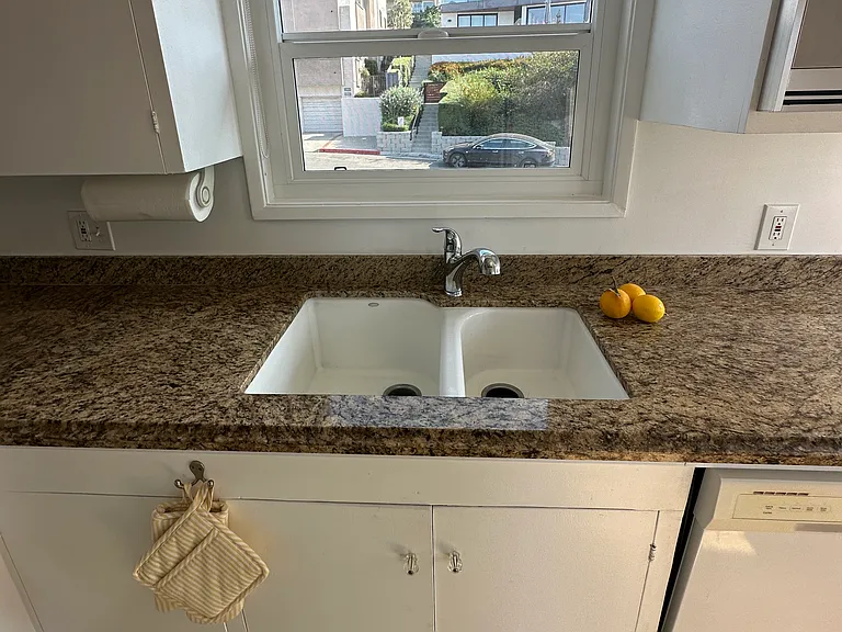 Well lit kitchen with large double sink & dishwasher