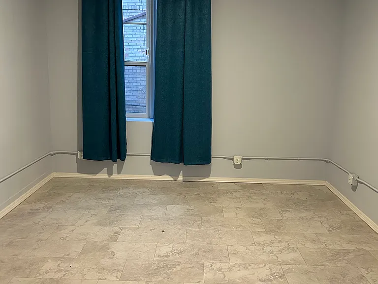 Bedroom #2: large window, slightly smaller than Bedroom #1, fan, AC/heating unit, several outlets, and closet