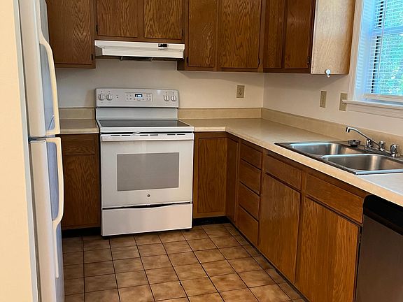 Kitchen with tile flooring comes with fridge, microwave, oven and dishwasher.