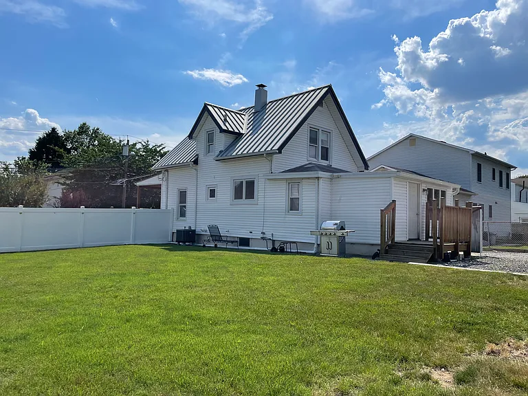 Large backyard with open green space, perfect for outdoor enjoyment, gardening, or relaxing outside.