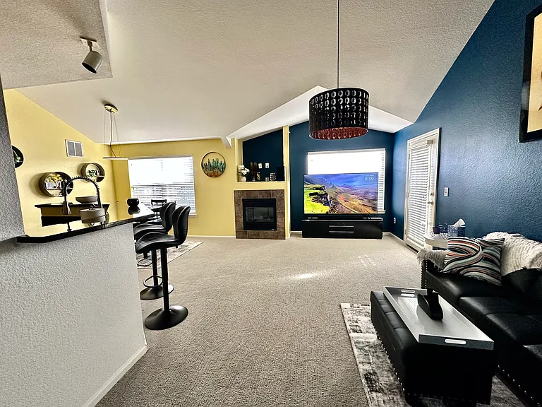The living room is equipped with a 75" smart TV and a sound bar.