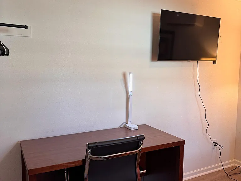 Work station with desk, ergonomic chair, and a smart TV