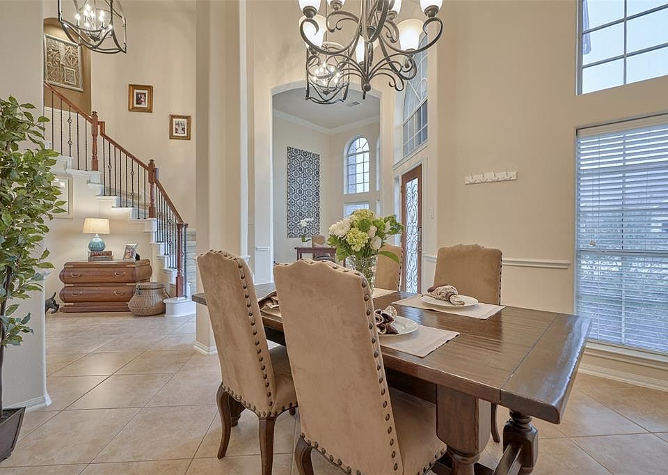 Stunning open home with soaring ceilings and cathedral windows. This view is taken from the Formal Dining Room looking towards the office/living room. Updated chandelier and ceiling light fixtures enhance the beauty of this home. Light and bright and