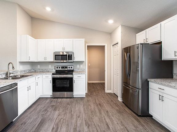 Open kitchen with breakfast bar - New home for sale in Lake Alfred, FL. Photo showcases the home lay