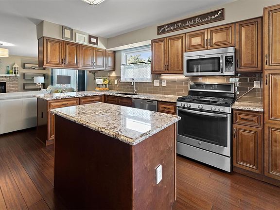 Beautifully remodeled kitchen features custom cabinets, granite counters, stainless appliances, gas stove, built-in microwave, subway tile back splash, center island, breakfast bar and durable bamboo wood floors. Opens to the family room and breakfast room.