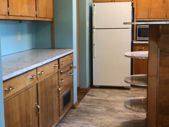 Much wooden counter space and well-lit, newly-painted kitchen with recent flooring