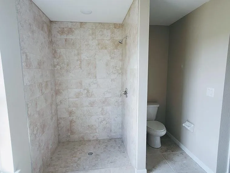 master tiled shower and toilet