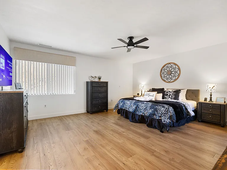The extra-large main bedroom features a king-sized adjustable base bed, a private en suite with double sinks, and a walk-in shower.