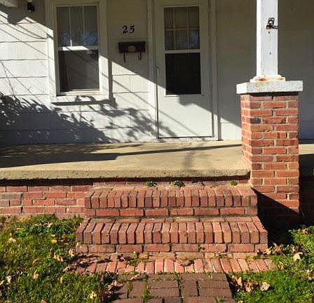Brick walkway to brick stairs at covered porch