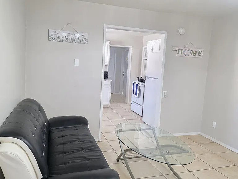 Open living area with tiled floors, comfortable seating, and a direct pass-through to the kitchen for easy everyday use.