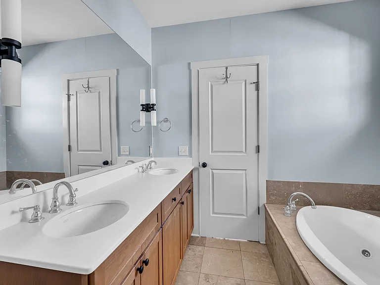 primary bath with dual vanity, walk in shower and whirlpool tub