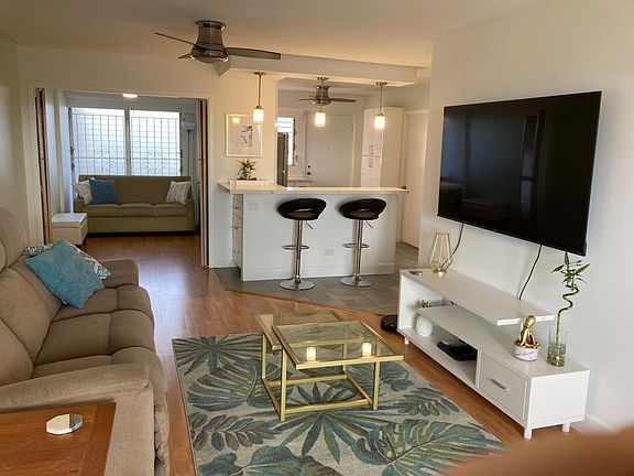 Living room and bonus room. Peninsula bar leading into the kitchen.