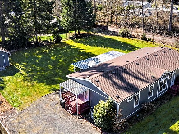 Over head view of property showing off large parking area leading to side covered porch, back outbuilding in the left corner and along back fence is great RV parking coming in from the road in back!