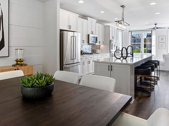 Dining room with LVP Floors and open kitchen in a DRB Homes Harlow Plan at WestRidge at Westphalia