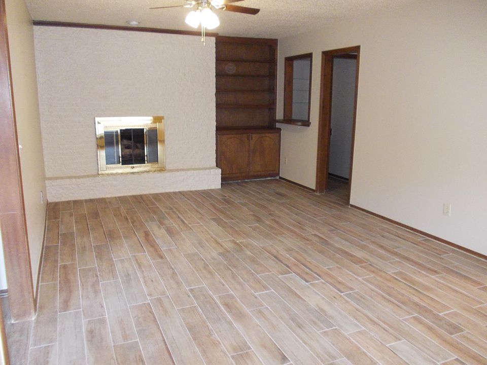 large living room with fireplace and built in cabinetry and glass slider to enter private yard
