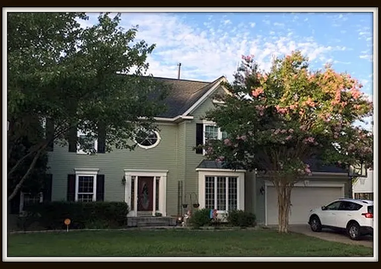 View of the front of the home with crepe mertle blooming, these trees bloom a few times each year, rest of yard has been re-landscaped.