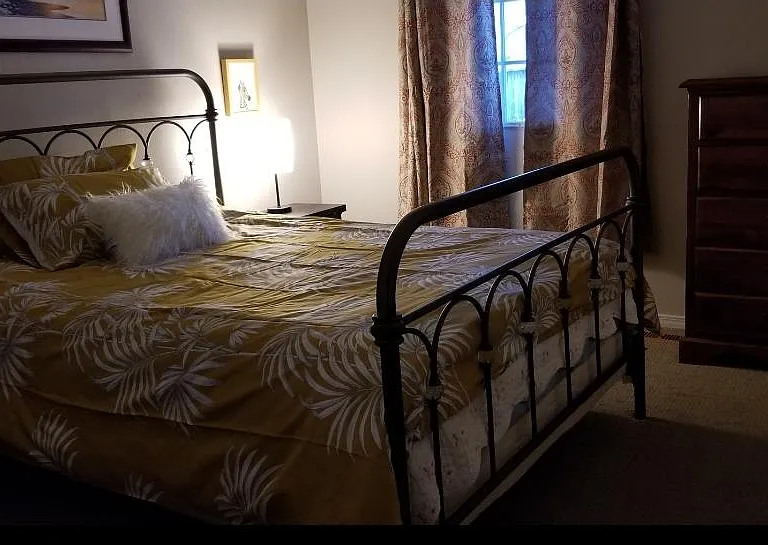 2nd bedroom, ground floor, with door leading out onto deck and back yard.