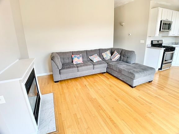 Living room with Bay Window, fireplace, hard-wood floors. Open to the Kitchen