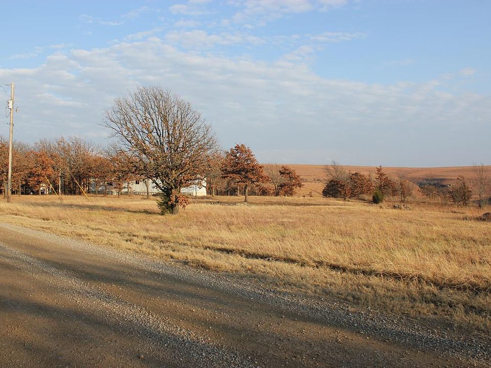View of house coming down gravel County Road