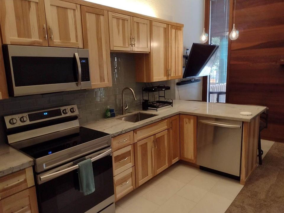 Renovated Kitchen with new appliances, cabinets, tile flooring, lighting and counter top seating for 3