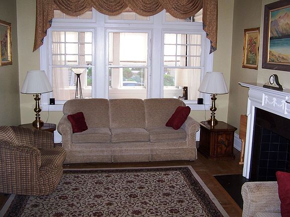 Spacious living room full of character with beautiful hardwood floors.