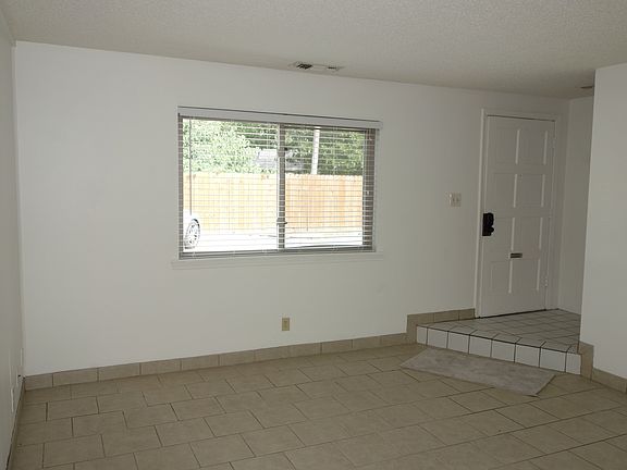 Tiled Living room view, Front door on the right.