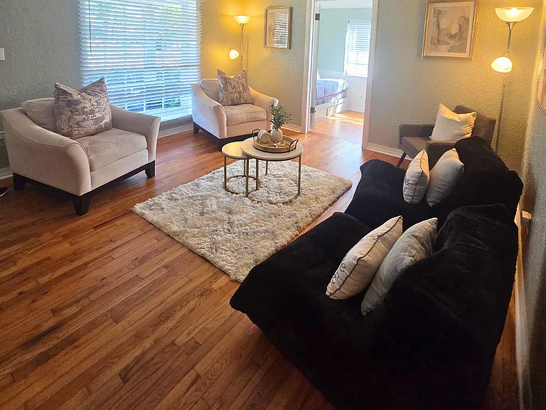 Cozy space with window blinds, center table, and decorative rug