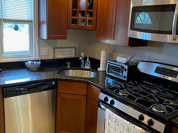 Stainless appliances including range (gas cooking), refrigerator, and microwave. Disposal also.