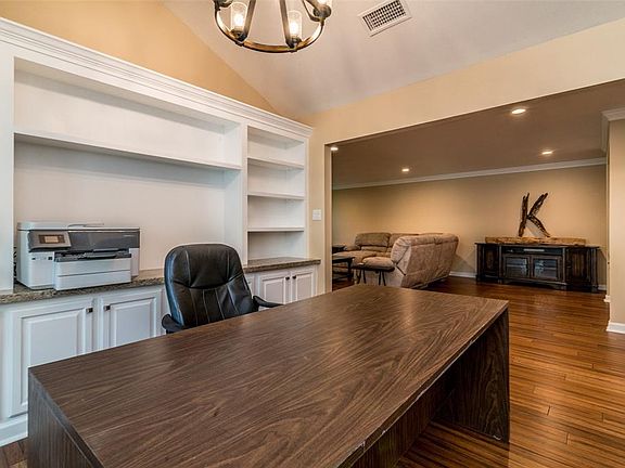 Formal dining room has builtin with granite counter top, currently being used as an office.