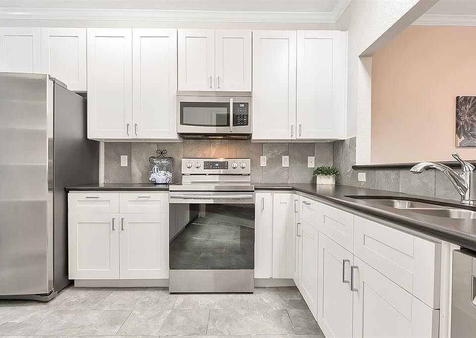 Beautiful recently updated Kitchen has white Shaker style cabinetry, concrete finish quartz countertops, recent stainless steel appliances, sink, and fixtures. Plenty of storage for all your kitchenware. Refrigerator remains with the condo.
