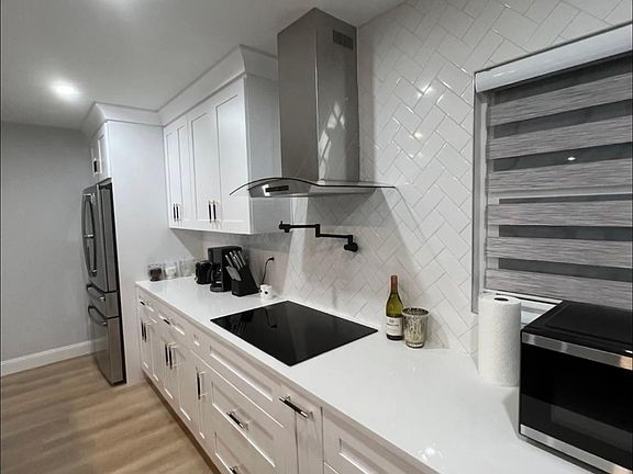 Kitchen renovated filled with plenty cabinet and cooking space.