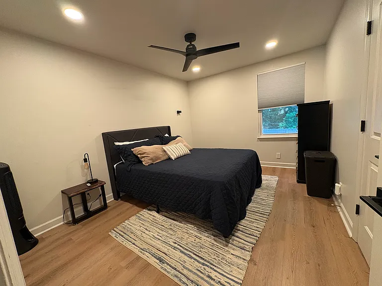 Main bedroom with a queen bed, chest, and full closet.