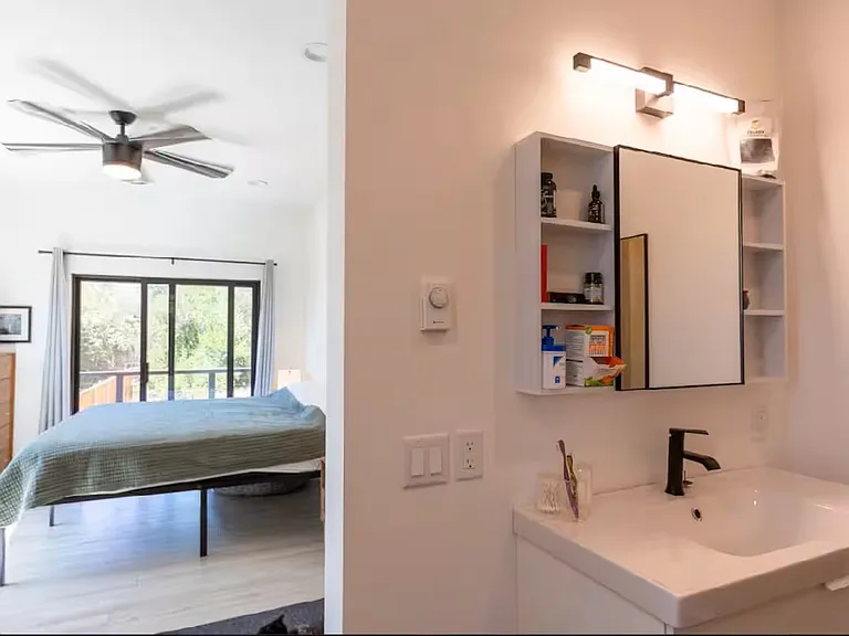 Primary bathroom sink-med cabinet and bedroom with deck.