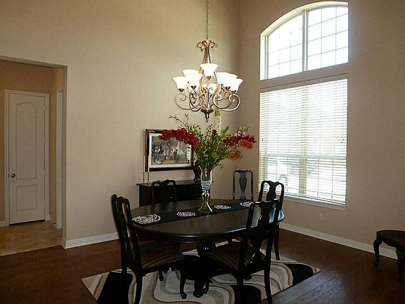 Formal Dining features High Ceilings, Arched Window & Hardwood Floors.