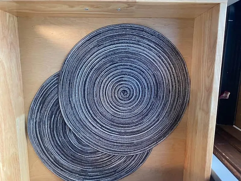 Elegant round woven placemat, perfect for stylish dining setups.