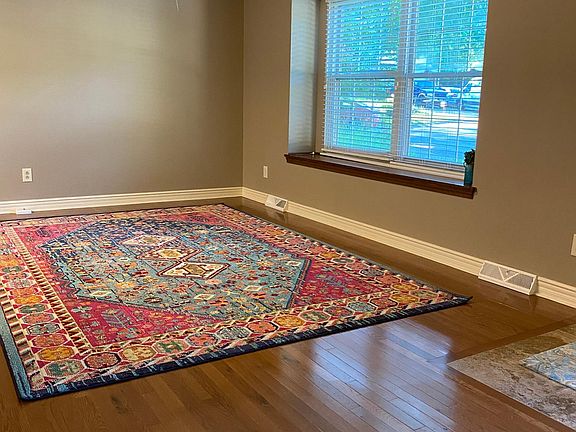 Living room with crown molding, ceiling fan, hardwood flooring