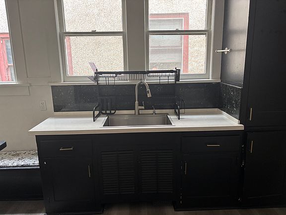 Beautifully redone kitchen sink area with quartz countertop