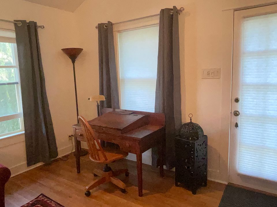 Living room with desk, door and window out to the deck.