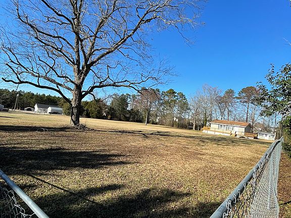 This is a picture from the far corner , looking across the one fenced acre to the front of the property and the road.
