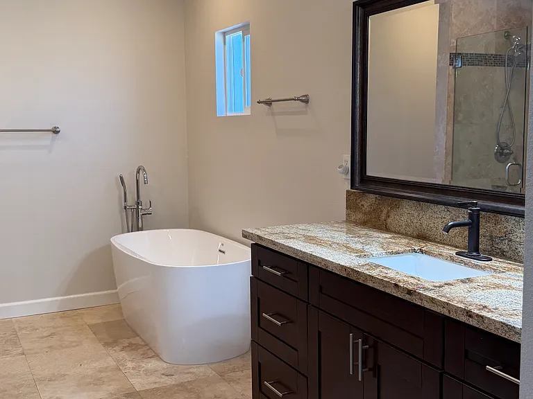 Primary bathroom with bathtub, shower and his-and-hers sinks