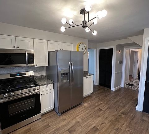 Kitchen with brand new appliances, updated flooring and new light fixtures.