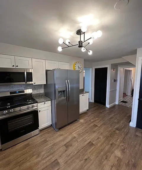 Kitchen with brand new appliances, updated flooring and new light fixtures.